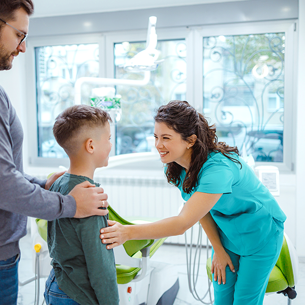 Dentist greeting child and parent