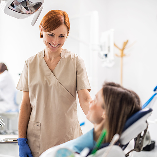 Dentist smiling at patient chair